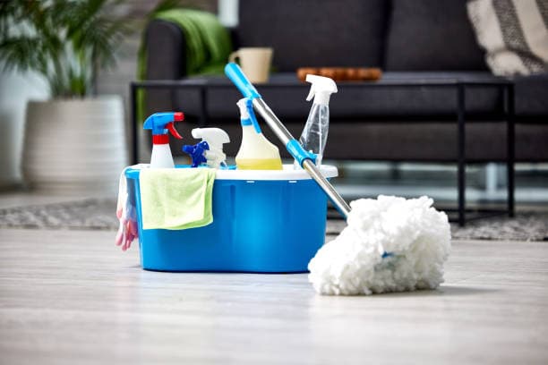 Professional house cleaner wiping kitchen bench in Toorak home